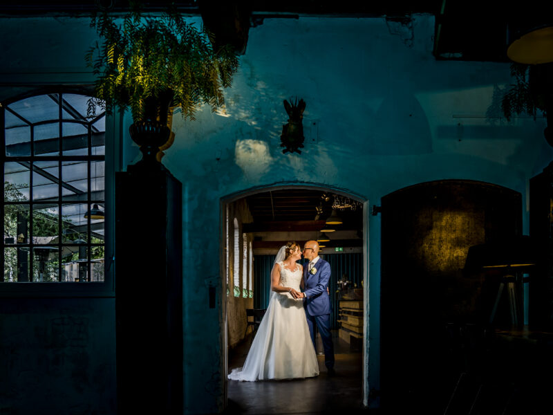 Bruidspaar uitgelicht in deuropening. Fotograaf Karin Keesmaat van Kijk-Kunst fotografie